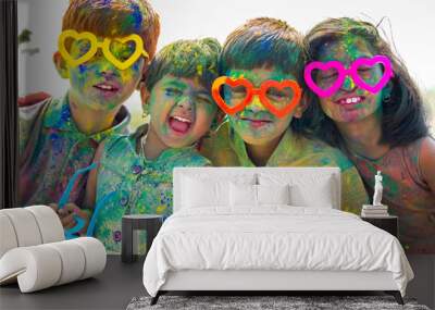 Group of Cheerful kids with fun spectacles Shouting at camera after playing with colourful holi powder during festival celebration. Wall mural