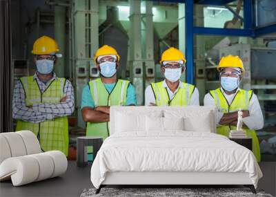 group of Confidently standing industrial workers with arms crossed by looking at camera at workplace - concept of workforce, occupation, blue collar jobs and safety Wall mural