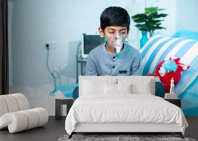 Worried sick kid with oxygen mask sitting on bed at hospital ward - concept of breathing problems, respiratory infection and health care treatment. Wall mural