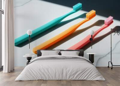 Three toothbrushes of different colors are lined up on a white counter Wall mural