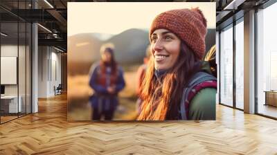 a young adult woman with a backpack on a mountain with a view of a valley and a mountain, nature and hiking, wanderlust, camping and hiking Wall mural