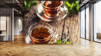 A cup of melissa tea with herbs on wooden table Wall mural