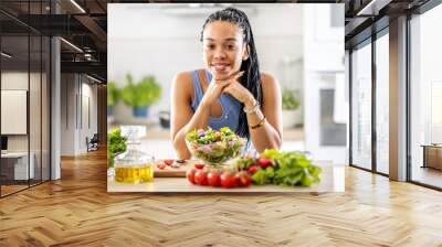 A good looking afro american girl prepared a healthy mixed salad of fresh vegetables Wall mural