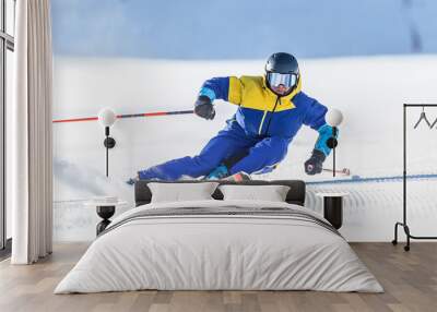 A young aggressive skier on an alpine slope demonstrates an extreme carving skiing style. Wall mural