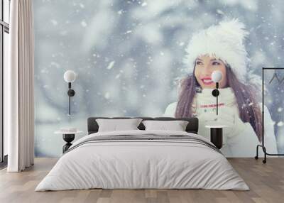 Beautiful smiling young woman in warm clothing with cup of  hot tea coffee or punch. The concept of portrait in winter snowy weather Wall mural