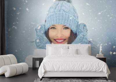 beautiful smiling young woman in warm clothing. the concept of portrait in winter snowy weather Wall mural