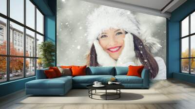 Beautiful smiling young woman in warm clothing. The concept of portrait in winter snowy weather Wall mural