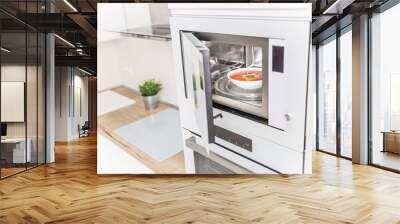 Built-in microwave oven  in the kitchen with tomato soup in white plate Wall mural