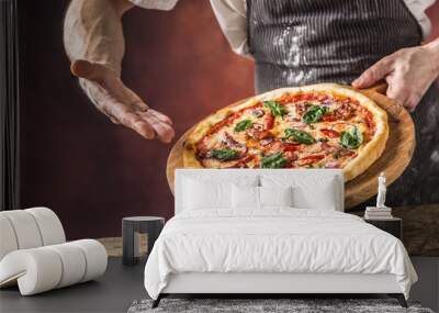 Chef and pizza. Chef offering pizza in hotel or restaurant Wall mural