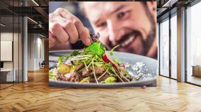 Chef in hotel or restaurant preparing salad with pieces of beef tenderloin. Wall mural