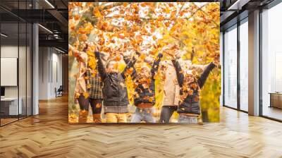 Family fun outdoors in the autumn by throwing fallen leaves up in the air Wall mural