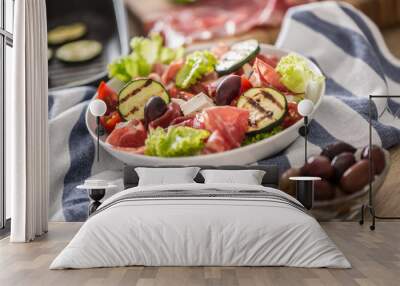 Fresh lettuce salad with grilled zucchini coppa di parma ham feta cheese olives tomatoes and olive oil Wall mural