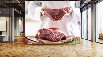 Fresh red meat cut in hands of a chef with chunk of meat on a wooden board Wall mural