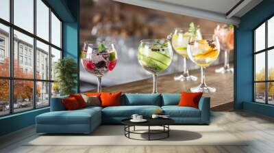 Gin tonic long drink as a classic cocktail in various forms with garnish in individual glasses such as orange, lemon, grapefruit, cucumber or berries Wall mural