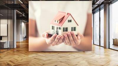 Hands of young woman holding model house Wall mural