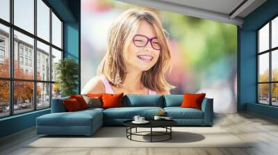 happy smiling girl with dental braces and glasses. young cute caucasian blond girl wearing teeth bra Wall mural