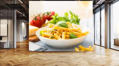 Pasta penne with chicken pieces mushrooms basil parmesan cheese and white wine.  Italian food in white plate on kitchen table Wall mural