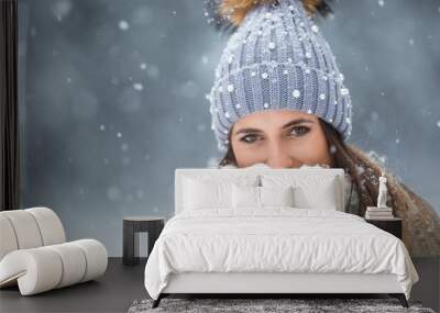 Portrait of young beautiful woman in winter clothes and strong snowing. Wall mural