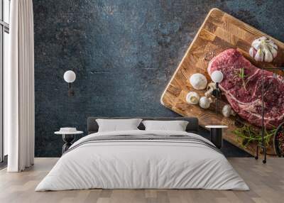 Rib Eye steak salt pepper spices garlic and mushroom. Raw beef meat on butcher board - top of view Wall mural