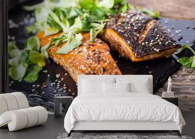 Salmon fillets. Grilled salmon, sesame seeds herb decorationon on vintage pan or black slate board. fish roasted on an old wooden table.Studio shot. Wall mural