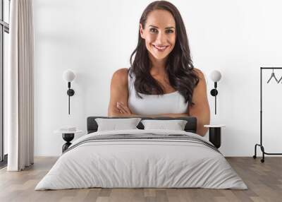 Studio portrait of an attractive dark-haired smiling woman with hands crossed in front of her chest. Isolated background Wall mural