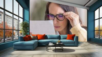 The woman has vision problems and reads the letter very close to her eyes and glasses Wall mural