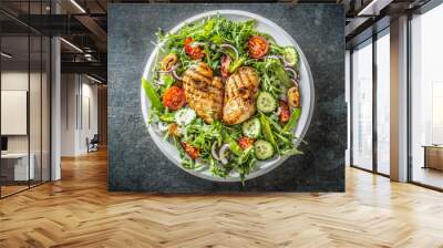 Top view of a healthy chicken salad in a white plate placed on the black rustic surface Wall mural