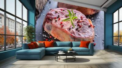 Two pieces raw beef shank on slate board and wooden table. Wall mural