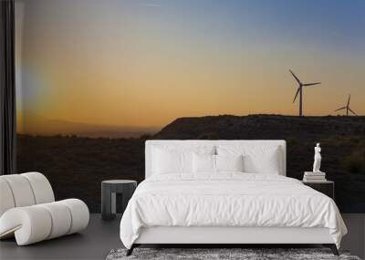 electric wind turbines farm with sunset light on arid landscape Wall mural