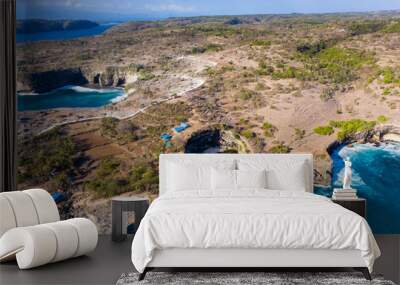 Aerial view of ocean waves crashing through a rocky archway into a round, isolated bay (Broken Beach, Nusa Penida, Indonesia) Wall mural