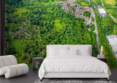 Top down aerial view of roads, houses and trees in a lush, green valley Wall mural