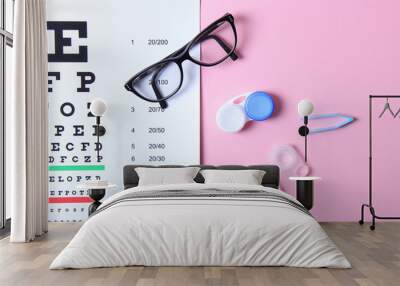 a table for checking vision, glasses and lenses for correcting vision on a colored background, top view. Ophthalmologist Accessories. Wall mural