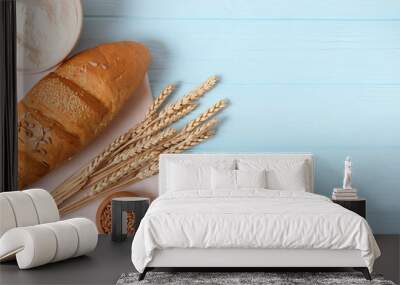 bread and wheat spikelets on wooden background top view. Wall mural