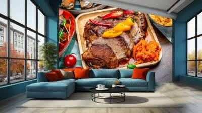 Roasted juicy pork with vegetables on a wooden plate Wall mural