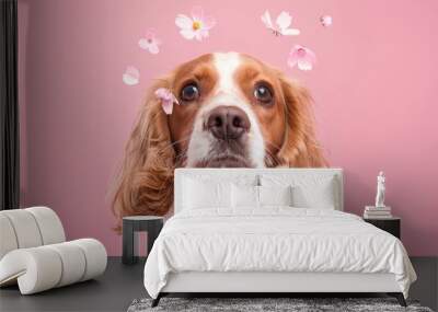 A dog with pink flowers in its hair. The dog is looking at the camera Wall mural