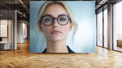 A woman with glasses is standing in front of a window. She has a serious expression on her face Wall mural