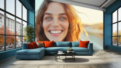 A woman with red hair and blue eyes is smiling and looking at the camera Wall mural