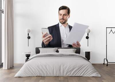 A businessman holding documents and a smartphone on a white background, depicting multitasking Wall mural