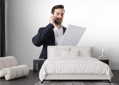 A professional man in a suit talking on the phone and holding a document, isolated on white background, representing a business concept Wall mural