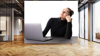 A woman in a black sweater appears tired or stressed at her work desk with a laptop, set against a white background Wall mural