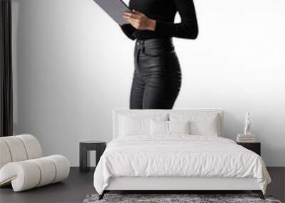 a woman in black attire studying a tablet, isolated on a white background, portraying the concept of Wall mural