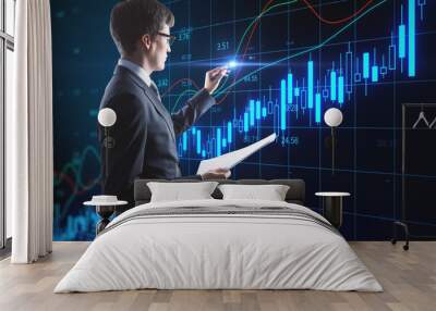 Businessman drawing glowing candlestick charts interface Wall mural