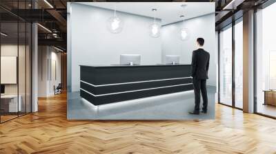 Businessman standing in modern reception room Wall mural