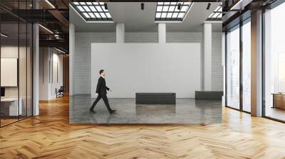 Businessman walking in contemporary exhibition hall interior Wall mural