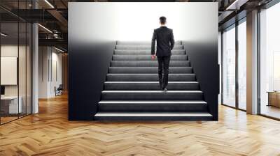 Businessman walking up concrete stairs towards a bright future, symbolizing growth and ambition. Wall mural