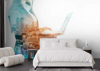 Businesswoman silhouette holding laptop on city background Wall mural