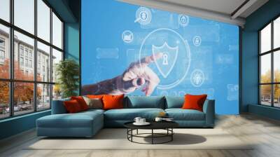 Close up of businessman hand pointing at abstract polygonal shield hologram on blue background. Antivirus and access concept. Double exposure. Wall mural