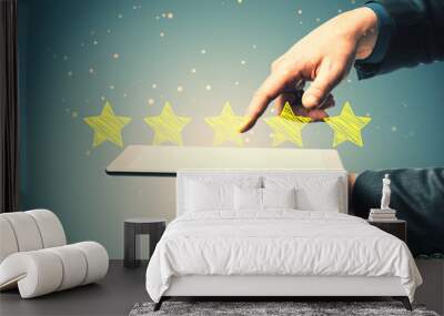 Close up of businessman hand pointing at tablet with 5 star rating on blurry background. Customer service and excellent feedback concept. Wall mural