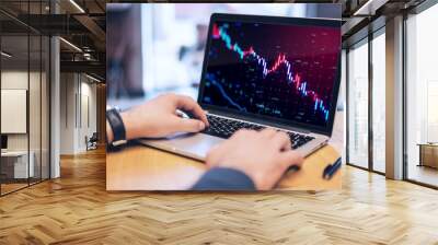 Close up of businessman hands using laptop with glowing downward candlestick forex chart on blurry background. Crisis, financial loss and crash concept. Wall mural