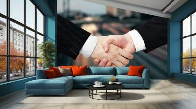 Close up of businessmen handshake on blurry city road background. Success, teamwork, deal and partnership concept. Wall mural